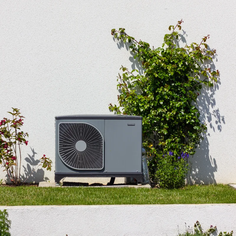 Warmtepomp geplaatst buiten woning bij groene tuin, warmtepomp installatie Bilthoven